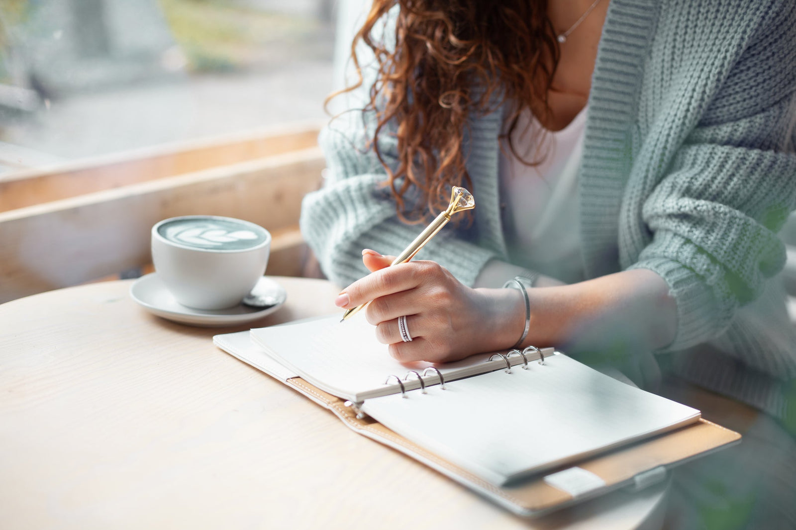 A woman sitting at a desk writing in a journal