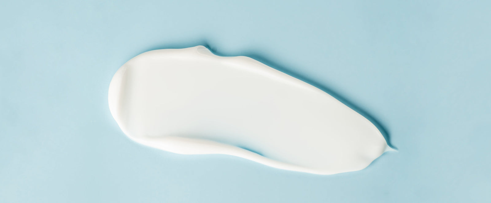 Cosmetic cream on blue background, close up