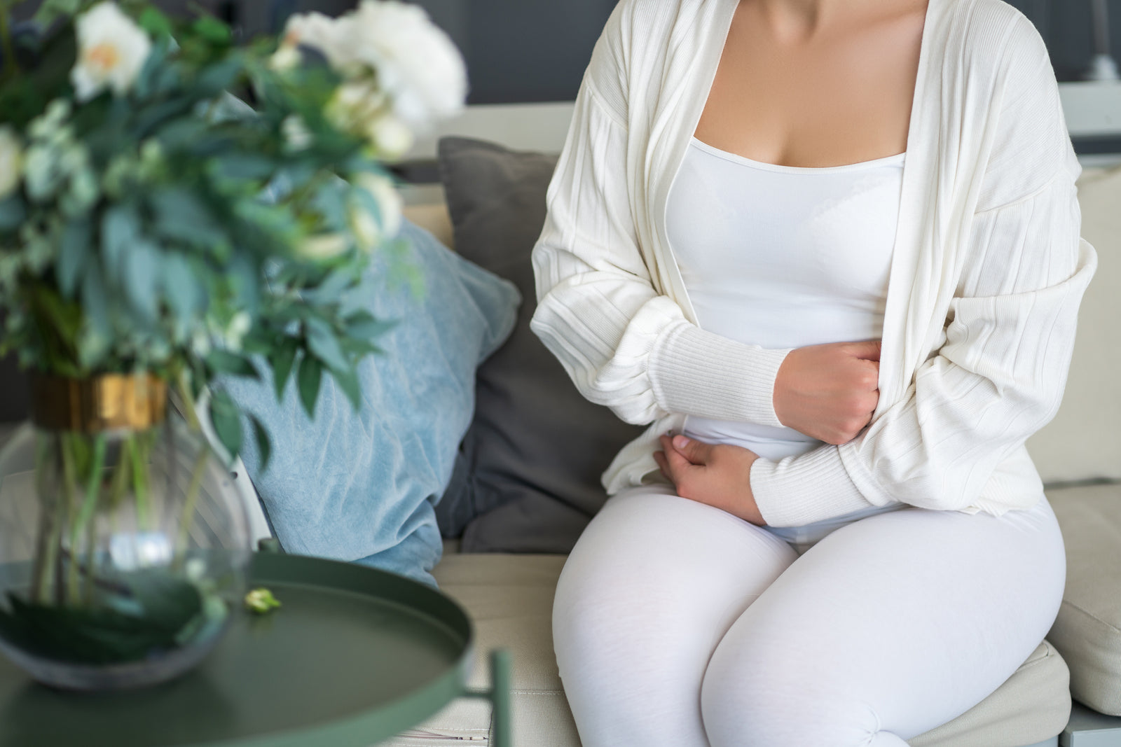A woman holds her stomach.