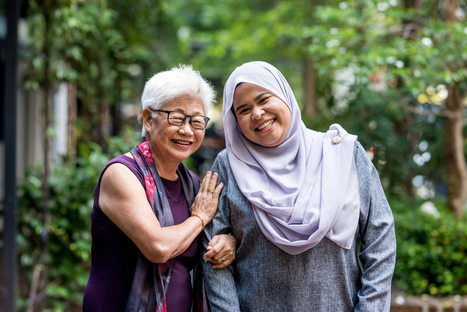 A mother and daughter smile together for a picture.