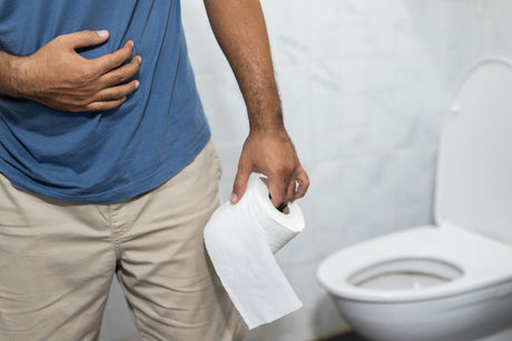 A man with toilet paper walking away from the toilet