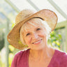 A woman in a sun hat smiling.