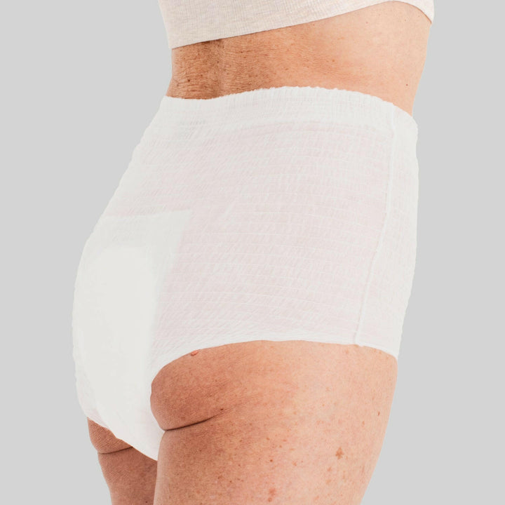 Woman wearing white Because overnight underwear with light grey background.