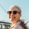 A woman smiling on a boat.