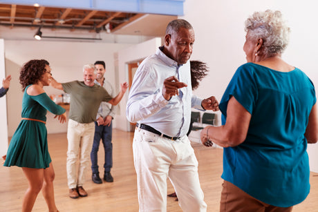 Older adults dancing happily in a dance studio