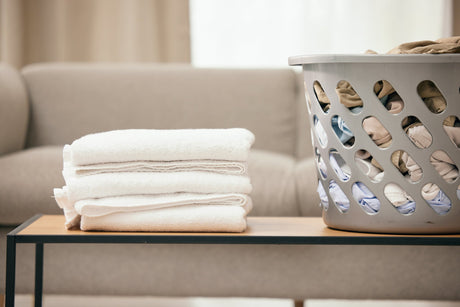 Laundry basket and clean towels folded on a table