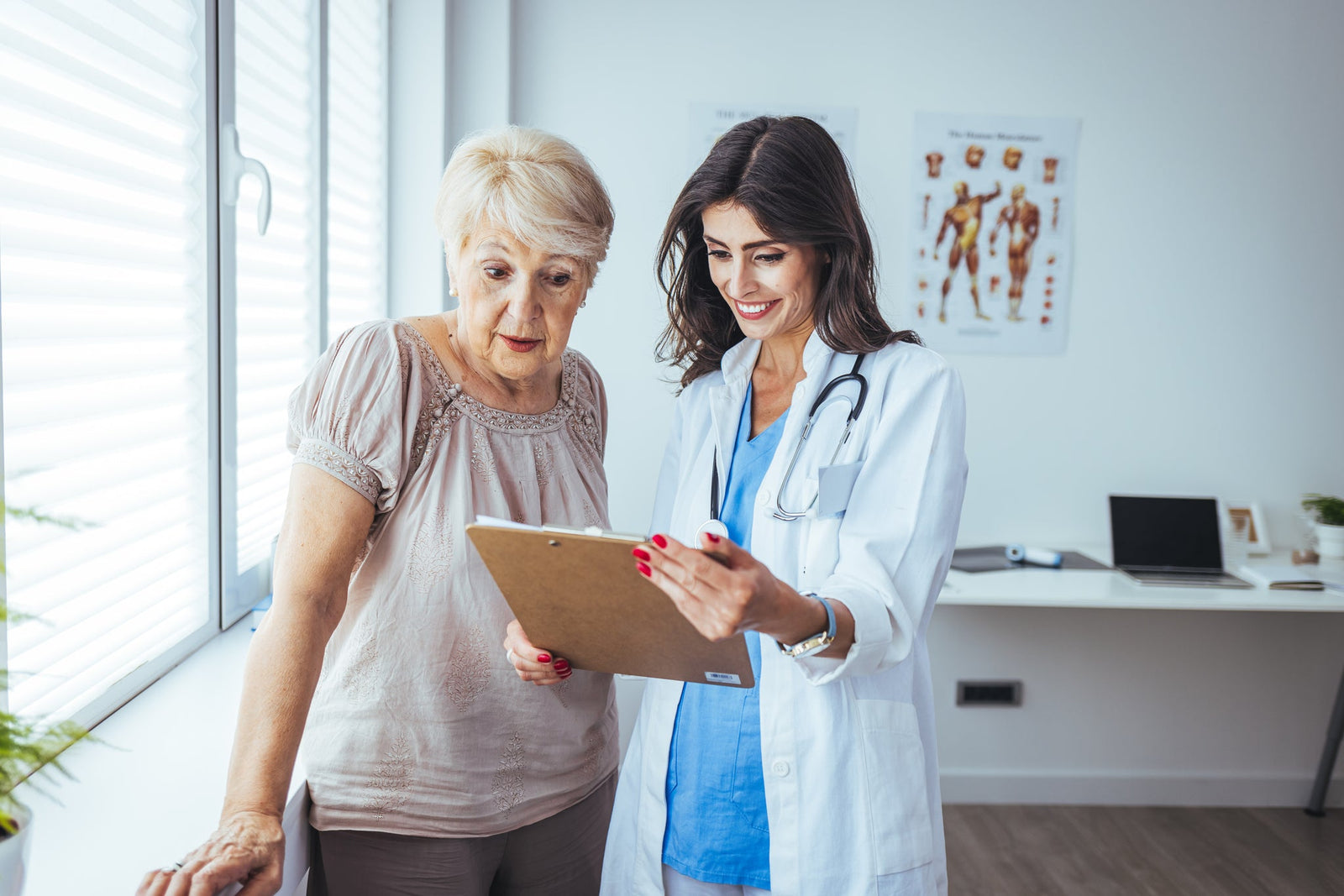 Older woman with her doctor looking at a clipboard
