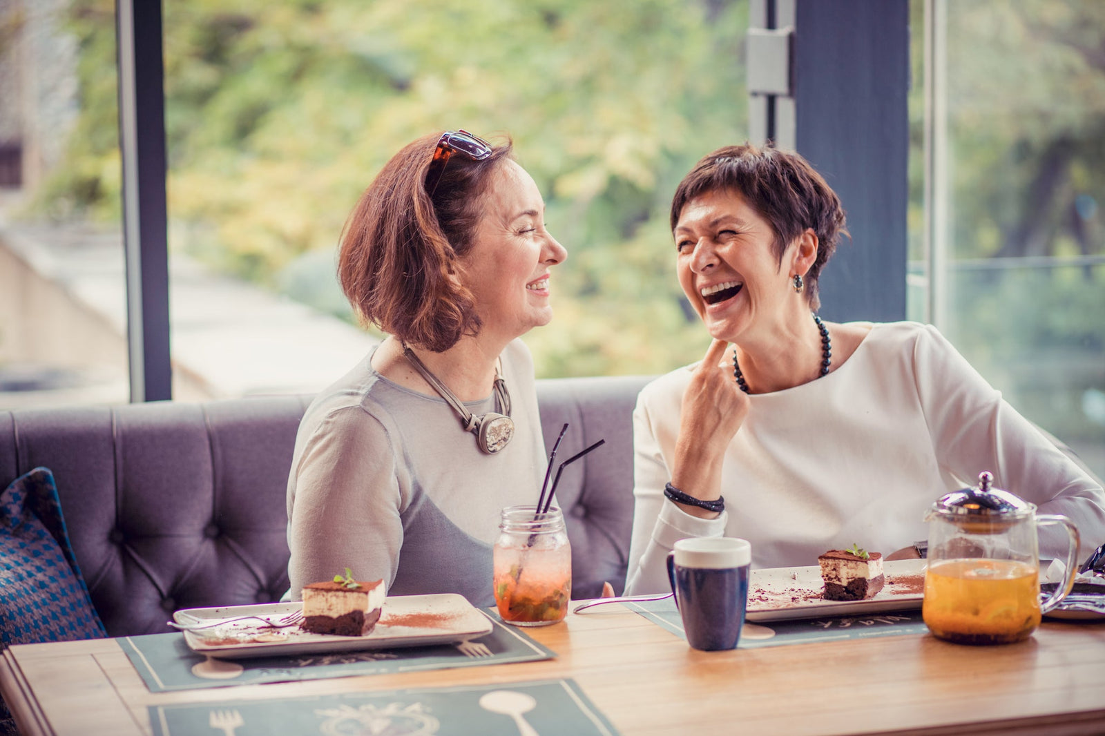 Two women chatting in a cafe while smiling