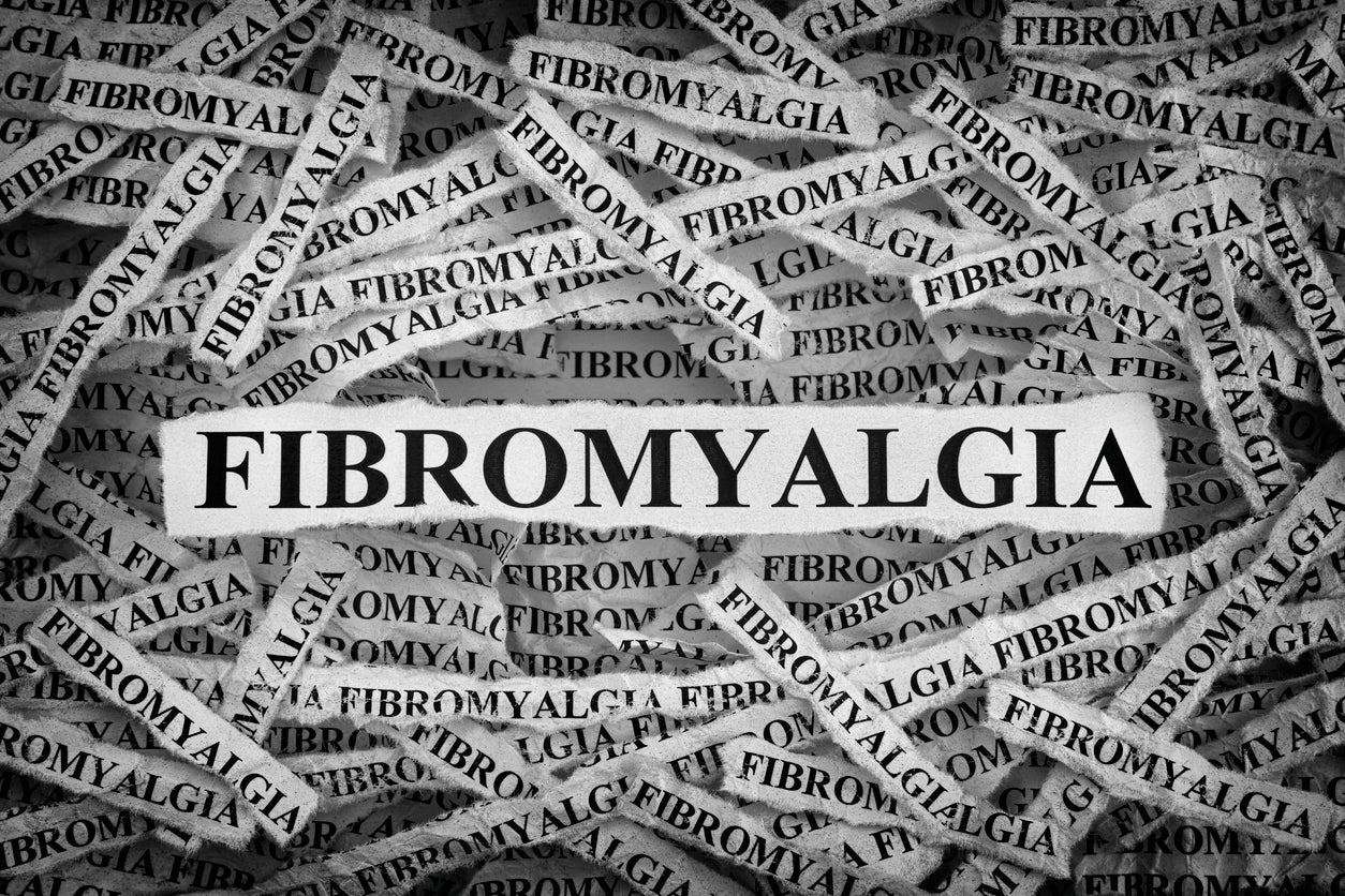 The word "Fibromyalgia" is present in the image in strips of newspaper type covering the image.