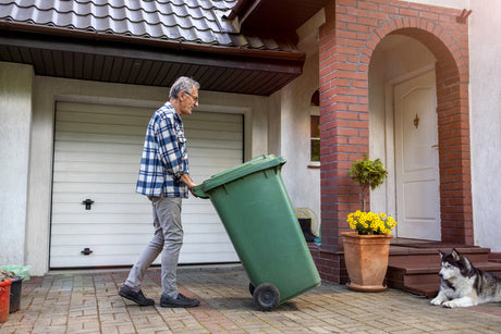 Man taking out green garbage bin