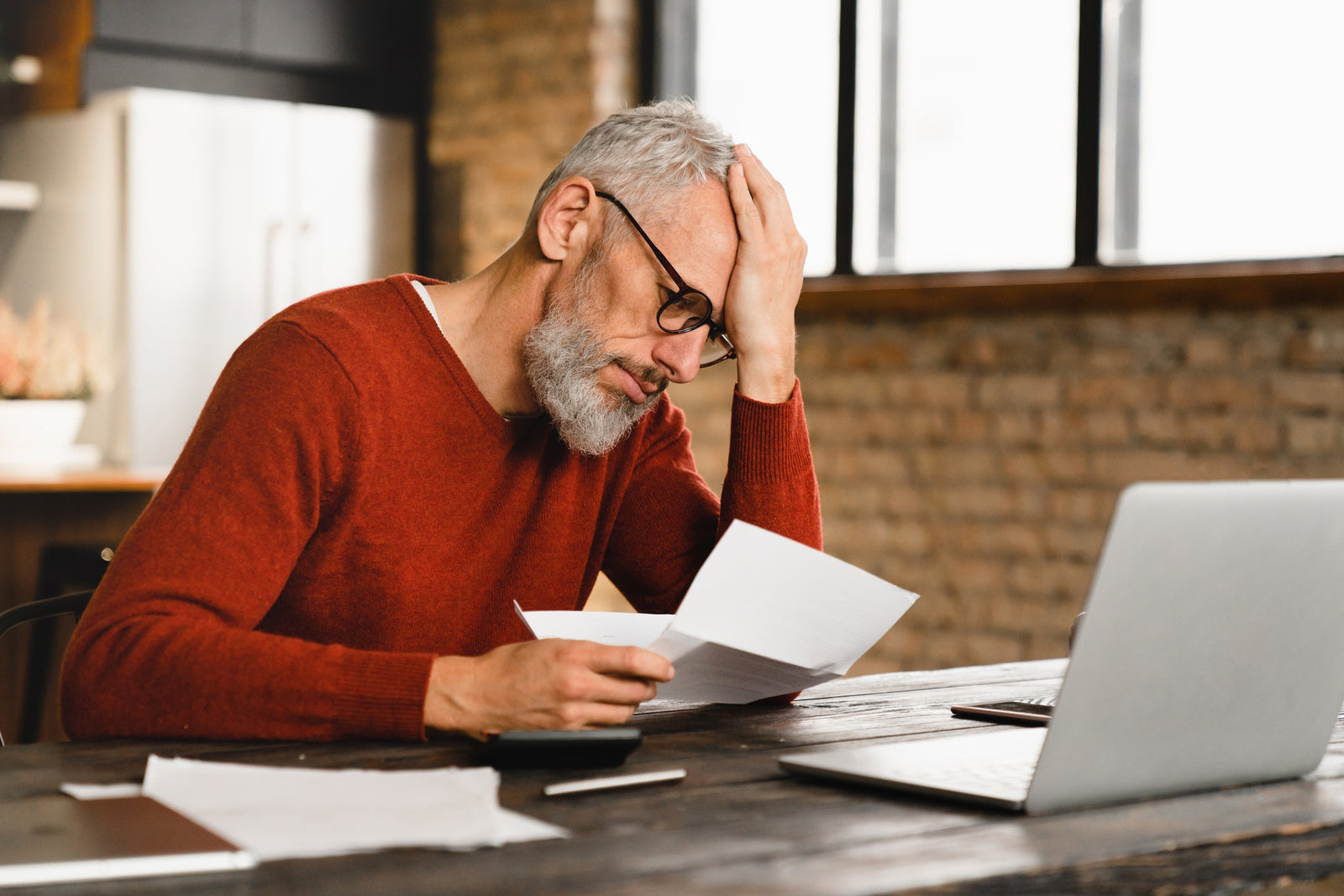 A man looks worried as he reviews bills.