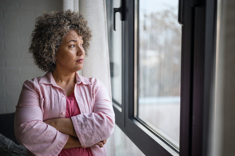 A woman stares out a window.