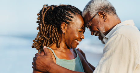 A couple smiling on a beach.