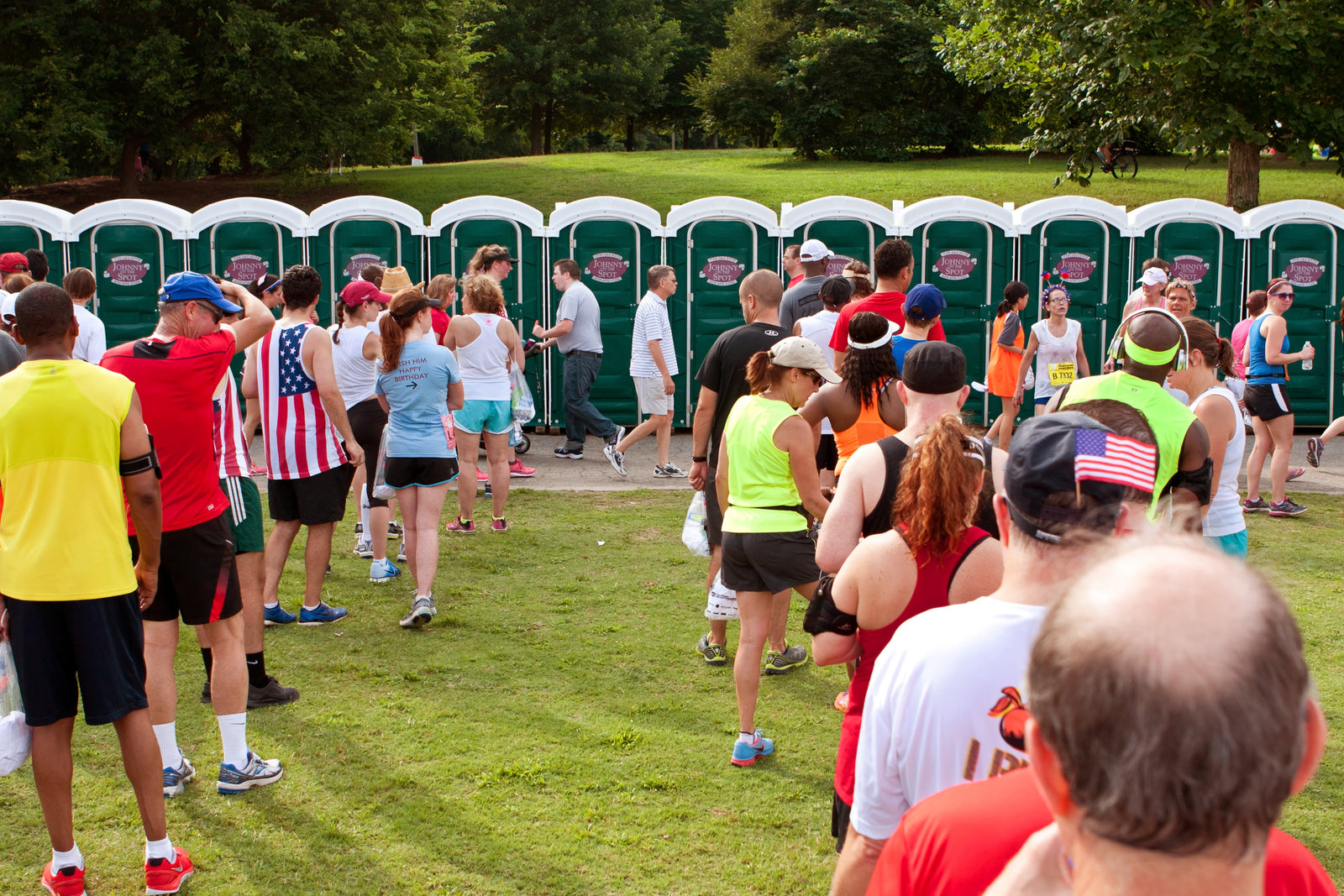 People wait in line for port-a-potties. 