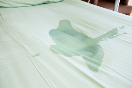 A bed with a wet stain.