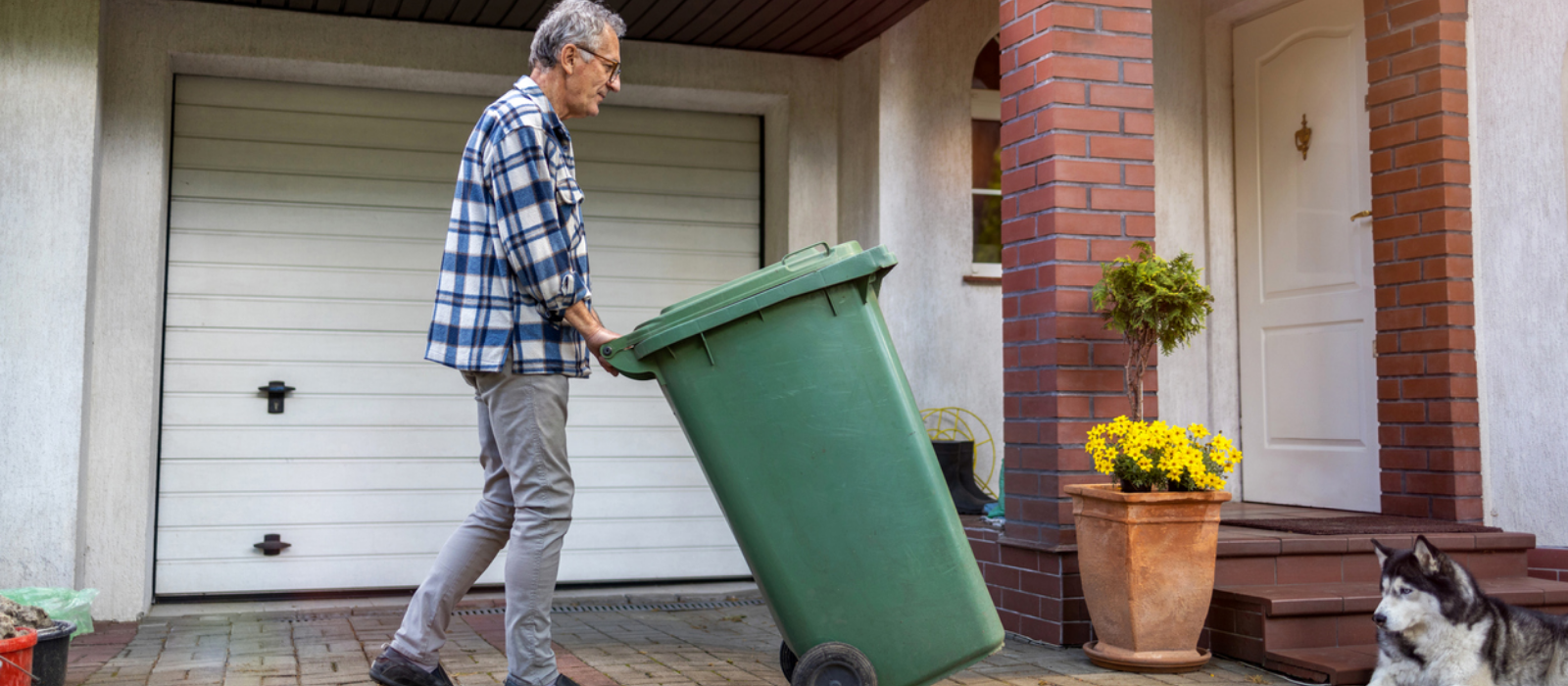 Man taking out green garbage bin