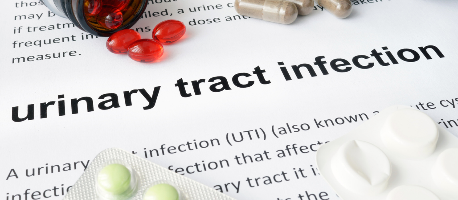 An image of text which reads "urinary tract infection" and various pills covering up other text.