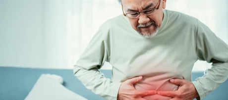A man holds his stomach in pain.
