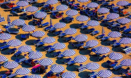 Identical umbrellas lined up on a beach.