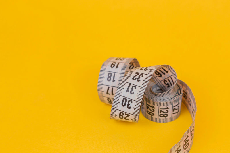 Body measuring tape on yellow background