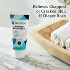 Tube of 'Because' Barrier Skin Cream on a marble surface with text about skin care benefits.