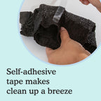 Hand holding a pair of Because Premium Maximum Plus Underwear for Women in Black on with text 'Self-adhesive tape makes clean up a breeze' on a light blue background.