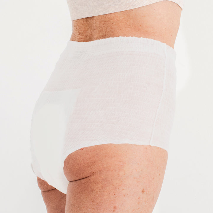 Model wearing white Because overnight underwear with light grey background.
