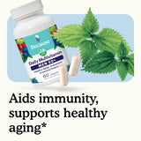 Multivitamin bottle with capsules and green leaves on a light blue background