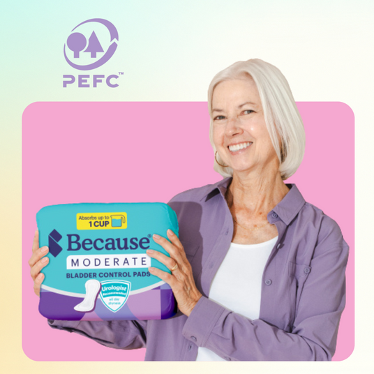 A woman holds a pack of Because Market Moderate Pads.