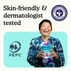 Smiling woman holding package of Because booster pads with text "skin-friendly and dermatologist tested" on white and teal background