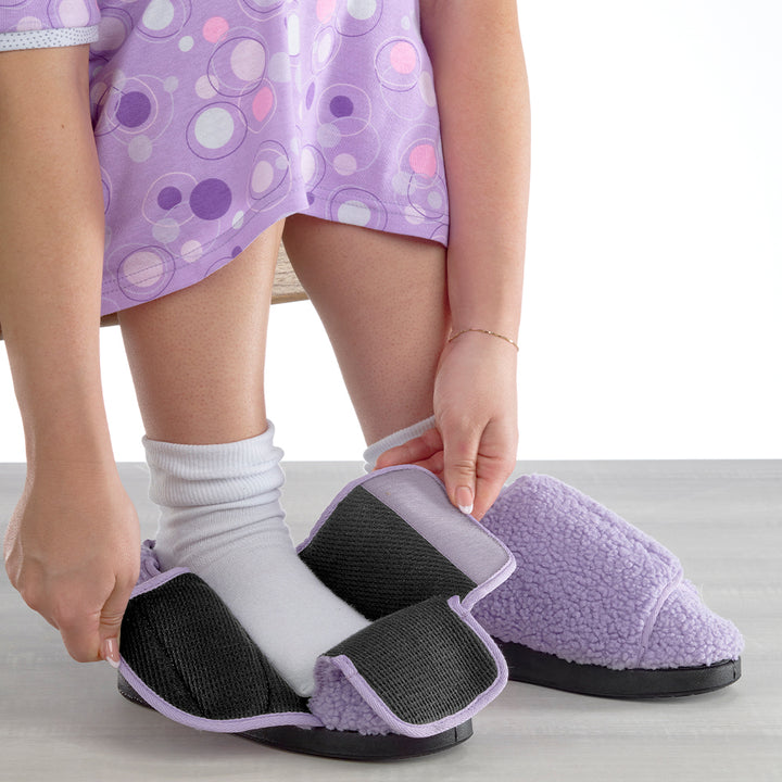Model putting on Silverts Women's Extra-Wide Easy Closure Slippers in purple on white background