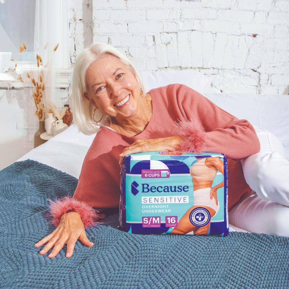 A woman laying down with sensitive overnight underwear