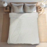 A bed showcasing how the bed protector should be placed on the bed.