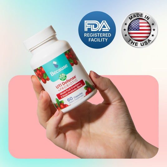 A hand holds Because Market UTI Defense Supplements with two seals reading "FDA registered facility" and "Made in the USA"