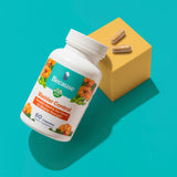 White supplement bottle with pumpkin and soy beans on label. Two yellow Bladder Control Capsules on top of box with two capsules 