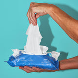 A hand pulling out an extra large wipe from a package