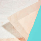 An orange bed protector showing the waterproof backing