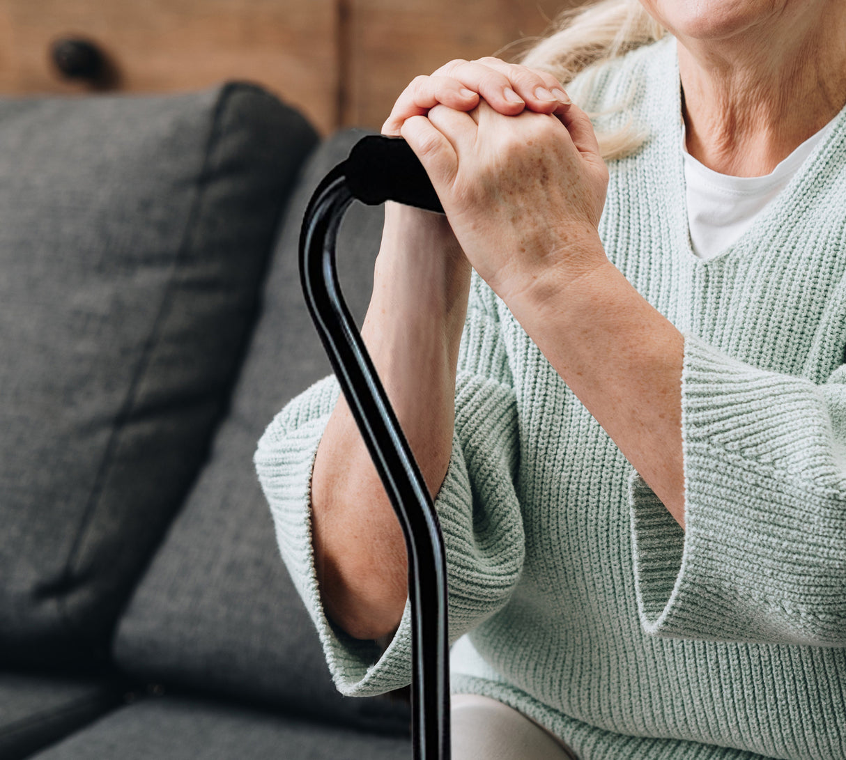 Woman holding on to comfortable foam handle on the Medline Adjustable Quad Cane.