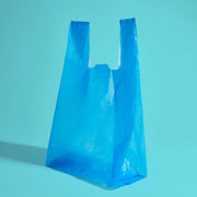 A blue disposable bag with handles that can tie together 