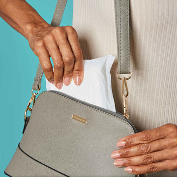 Woman sliding an overnight pad discreetly into her purse