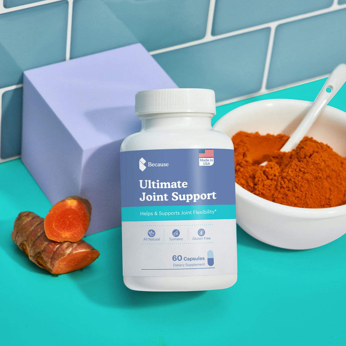 Ultimate joint support vitamin bottle sitting next to fresh and crushed turmeric