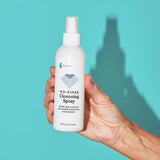 Hand holding a Because No-Rinse Cleaning Spray with Gentle spray cleanser with soothing Aloe Vera and Vitamin E. 6 fl oz (177 ml)